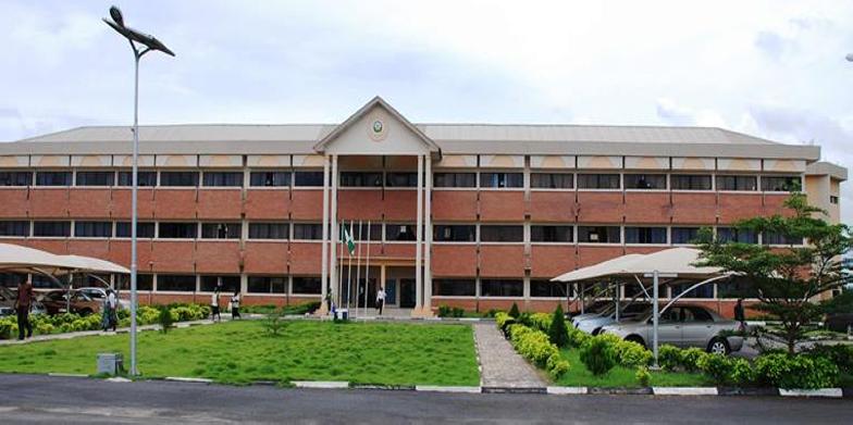 Osun State University, Osogbo, building with a lawn and cars parked in front