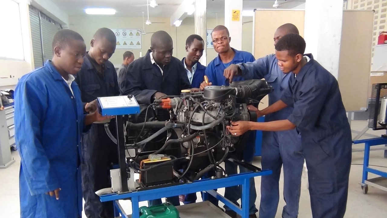 photo shows students operating a machine in the workshop