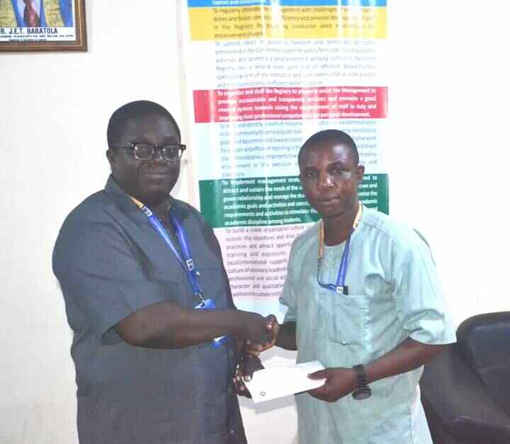 Photo showing the Registrar of AJayi Crowther University Dr. Jadesola Tai Babatola presenting letter of appointment to Engr. Oluwole Aderogba Olaniyi as the institution’s first director of works